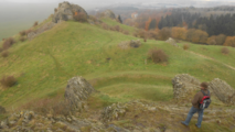 Wanderer auf dem Dörnberg mit felsiger Hügellandschaft