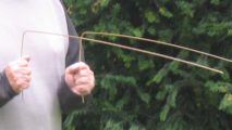 Person hält eine gegabelte Wünschelrute beim Rutengehen