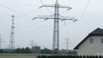 Hochspannungsleitung im Feld nahe einem Wohnhaus