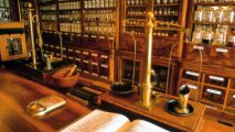 Historische Apotheke mit Messingwaagen und aufgeschlagenem Buch
